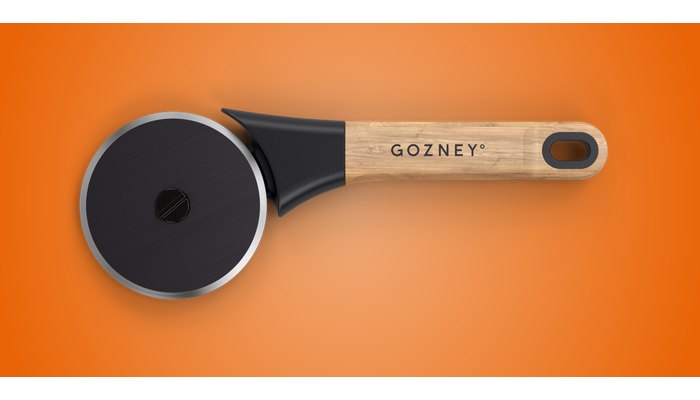 Gozney pizza cutter with a steel wheel and a solid wood handle